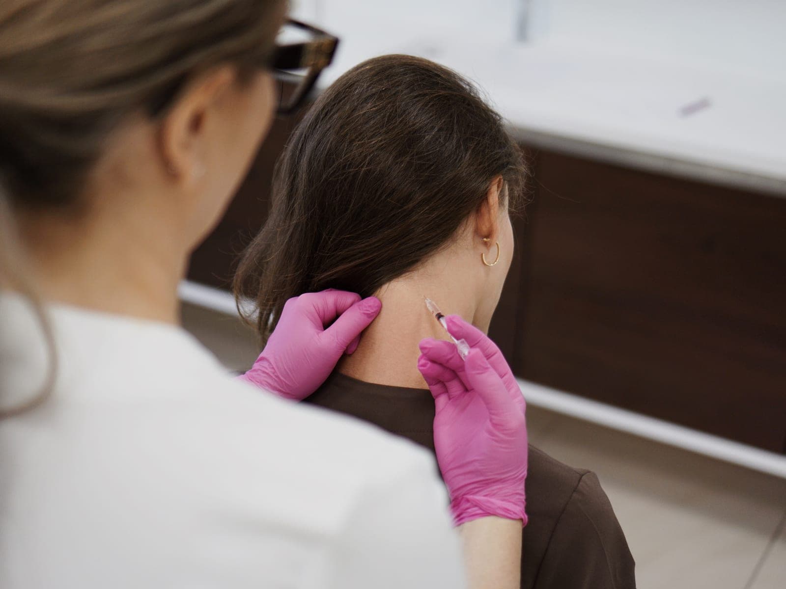 Podanie toksyny botulinowej w okolicę karku podczas leczenia migreny — Kliniki Dr Kuschill MEDESTETIS